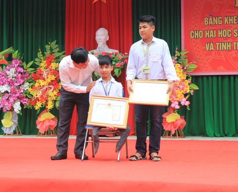 Ông Doãn Hồng Hà trao bằng khen của Bộ trưởng Bộ GD-ĐT Phùng Xuân Nhạ cho hai em Minh và Hiếu.