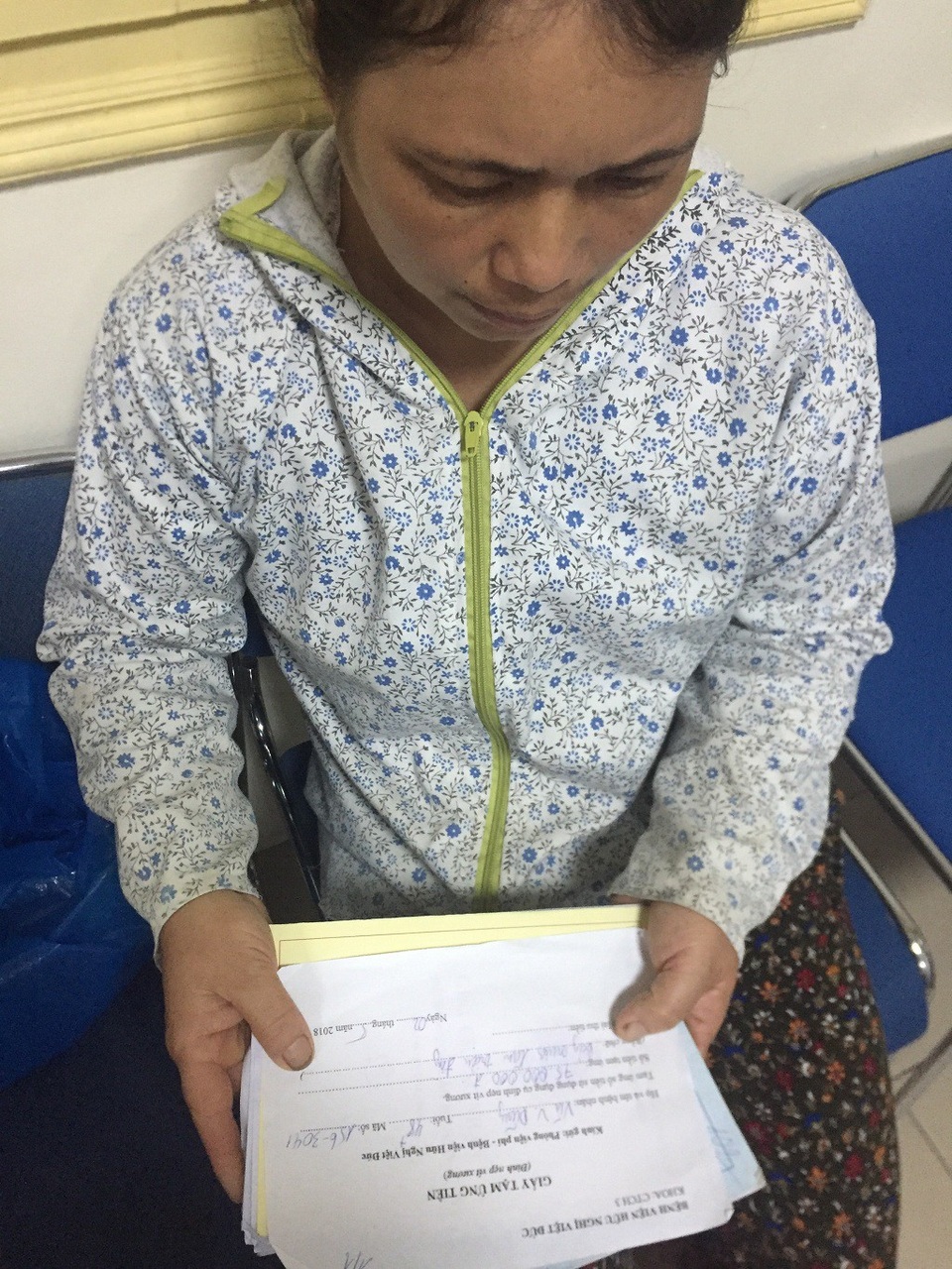 Thiếu hơn 70 triệu đồng, người bố nghèo có nguy cơ liệt mãi mãi - 3 Chị Hà (vợ anh Dũng) bủn rủn tay chân cầm tờ giấy tạm ứng viện phí.
