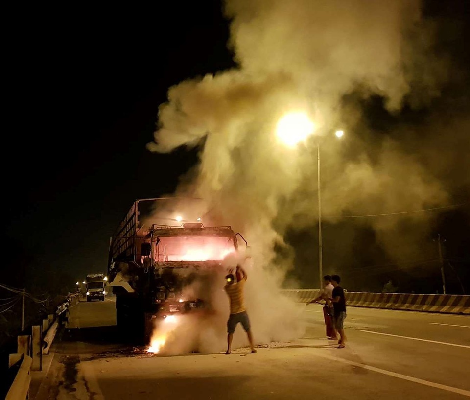 Đang chạy, xe tải bỗng nhiên bốc cháy ngùn ngụt - 1 Tài xế, phụ xe dùng bình chữa cháy dập lửa lúc chiếc xe bốc cháy.