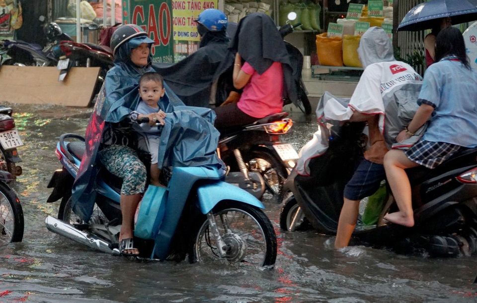 Sài Gòn mưa to, học sinh bì bõm lội nước về nhà - 12 Một em nhỏ tò mò, thích thú đi dưới mưa