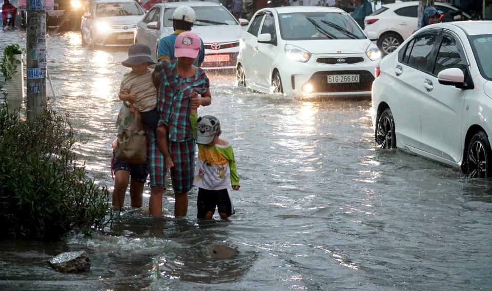 Sài Gòn mưa to, học sinh bì bõm lội nước về nhà - 7 Nhiều phụ huynh dắt con lội nước về nhà sau giờ tan lớp