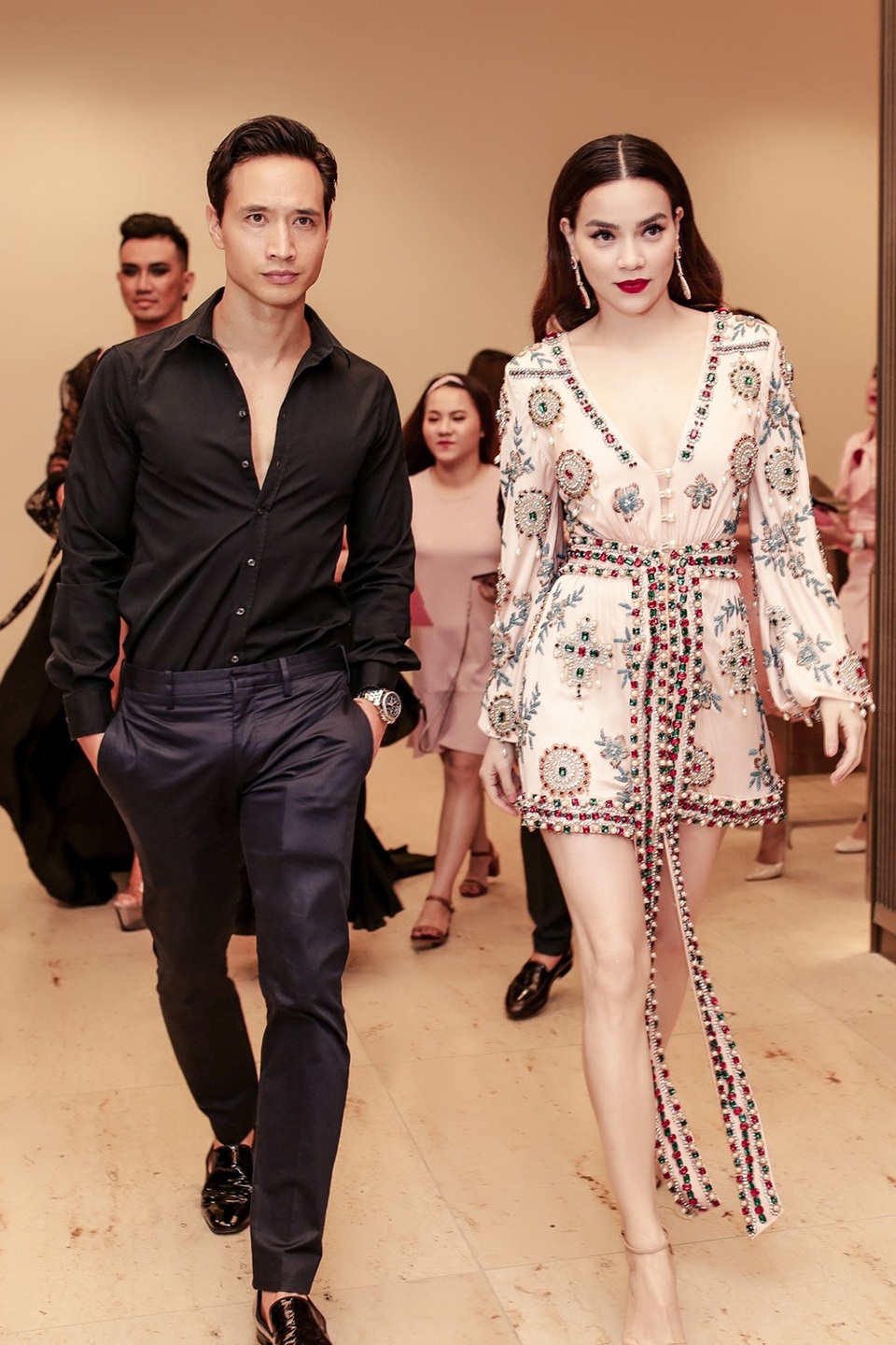 Kim Lý chọn trang phục kiểu dáng đơn giản tông đen còn Hà Hồ diện trang phục hồng nhạt khoét ngực sâu cuốn hút.