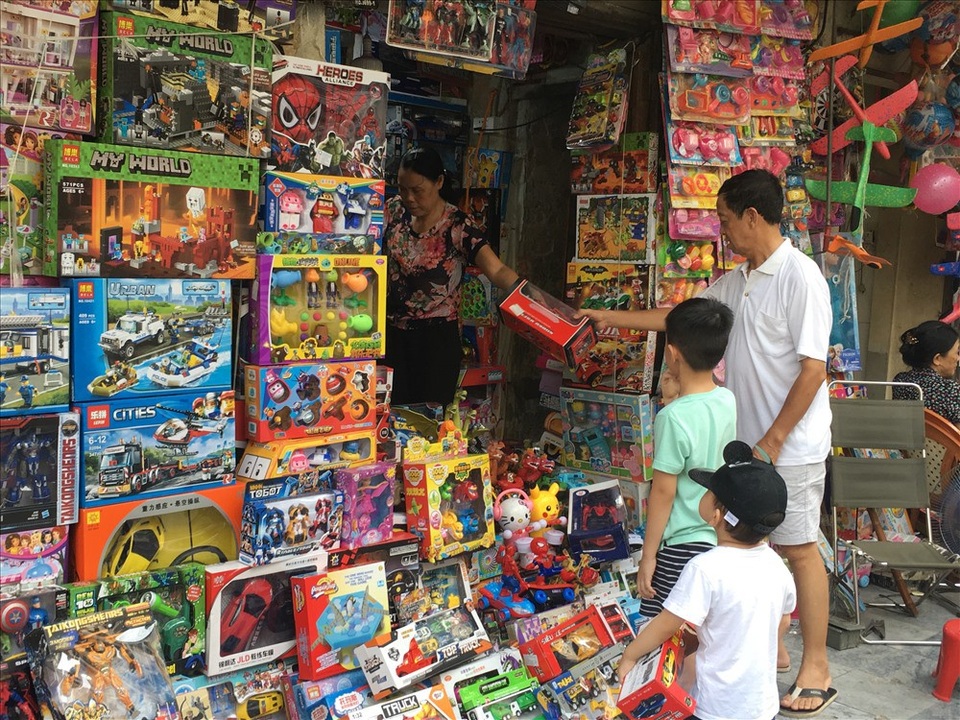 
Phụ huynh dẫn con đi mua đồ chơi nhân dịp Tết thiếu nhi 1.6 tại phố Hàng Mã. Ảnh: Đ.P
