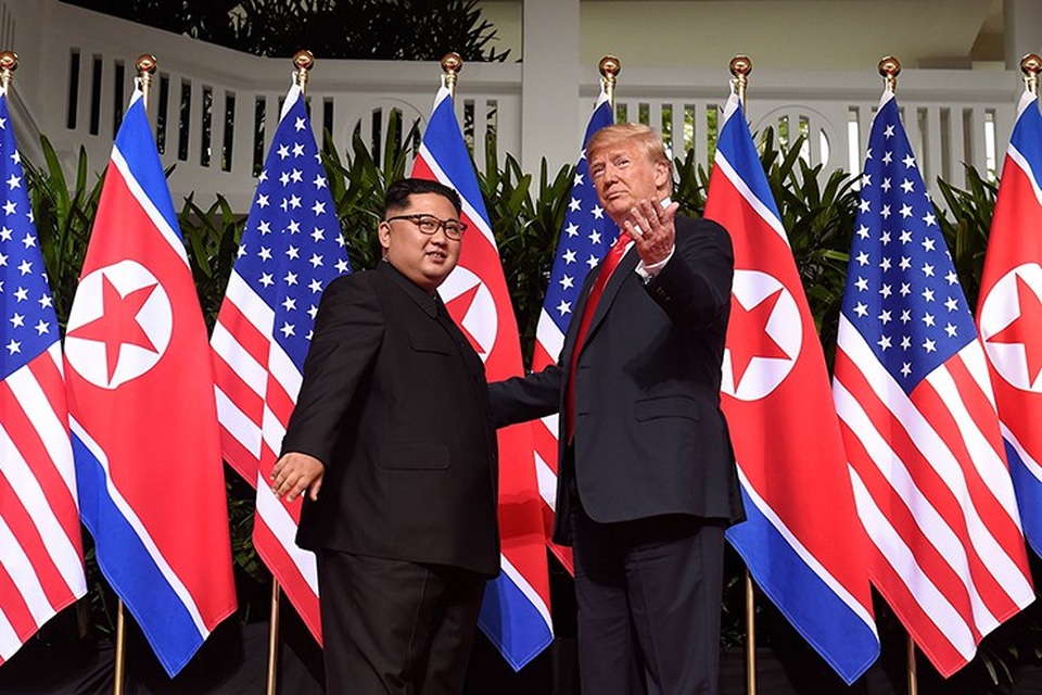 Những khoảnh khắc thân mật đầu tiên giữa ông Trump và ông Kim - 4 Cả hai nhà lãnh đạo đều mỉm cười khi lần đầu gặp nhau. Ông Trump được nhìn thấy vỗ nhẹ vào tay ông Kim Jong-un trong lúc bắt tay.