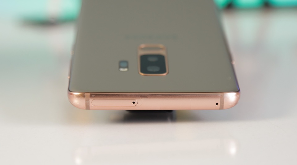 Khung viền được phủ màu vàng cùng tông với nắp lưng, phía đỉnh máy là khe cắm thẻ SIM, thẻ nhớ và micro.
