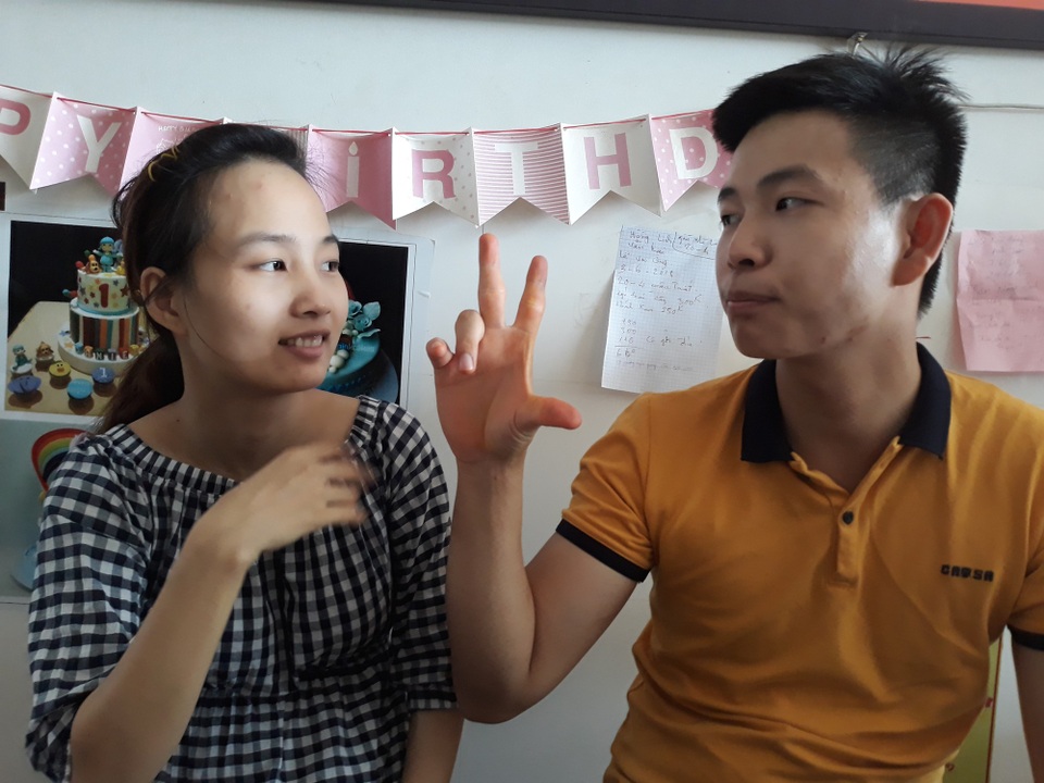 Quảng Ngãi: Lời yêu không âm sắc của đôi vợ chồng khuyết tật - 3 Hai vợ chồng giao tiếp bằng ngôn ngữ cử chỉ, giao tiếp với khách hàng thông qua cây viết và cuốn sổ