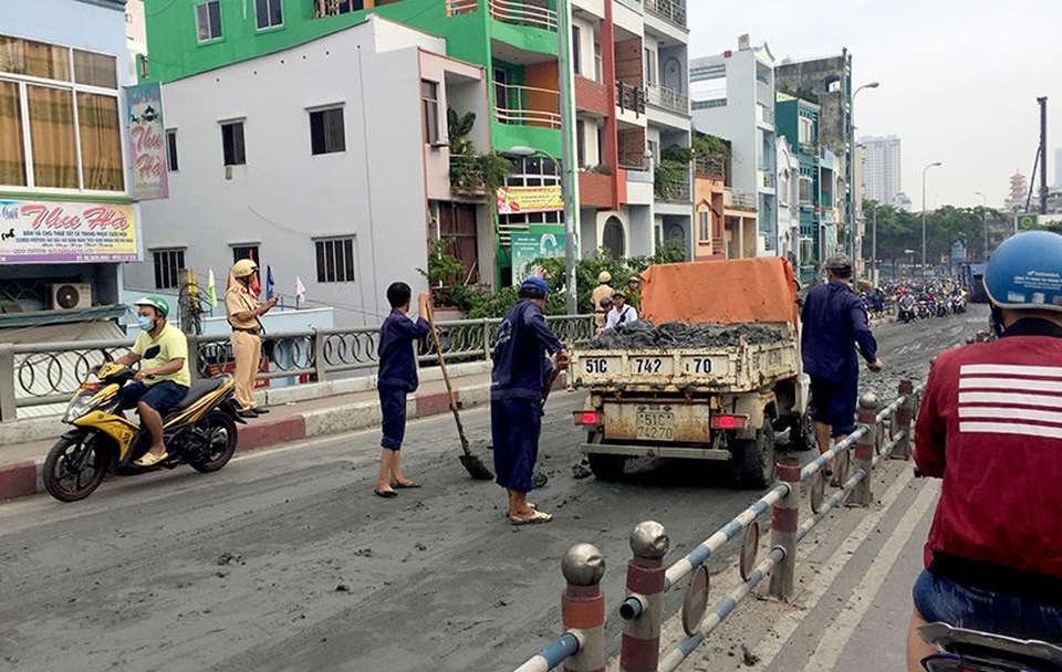 Bùn đổ tràn trên cầu, nhiều xe máy trượt ngã - 3 Lực lượng chức năng dọn dẹp mặt đường