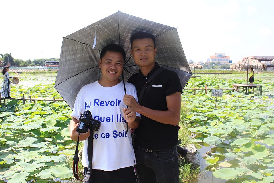 Kiếm bạc triệu từ những dịch vụ "ăn theo" mùa sen - 4
Phó nháy Nguyễn Minh Tiến (phải) mỗi ngày kiếm từ 1,5 - 2 triệu đồng nhờ nghề chụp ảnh cho khách tại đầm sen Hồ Tây.