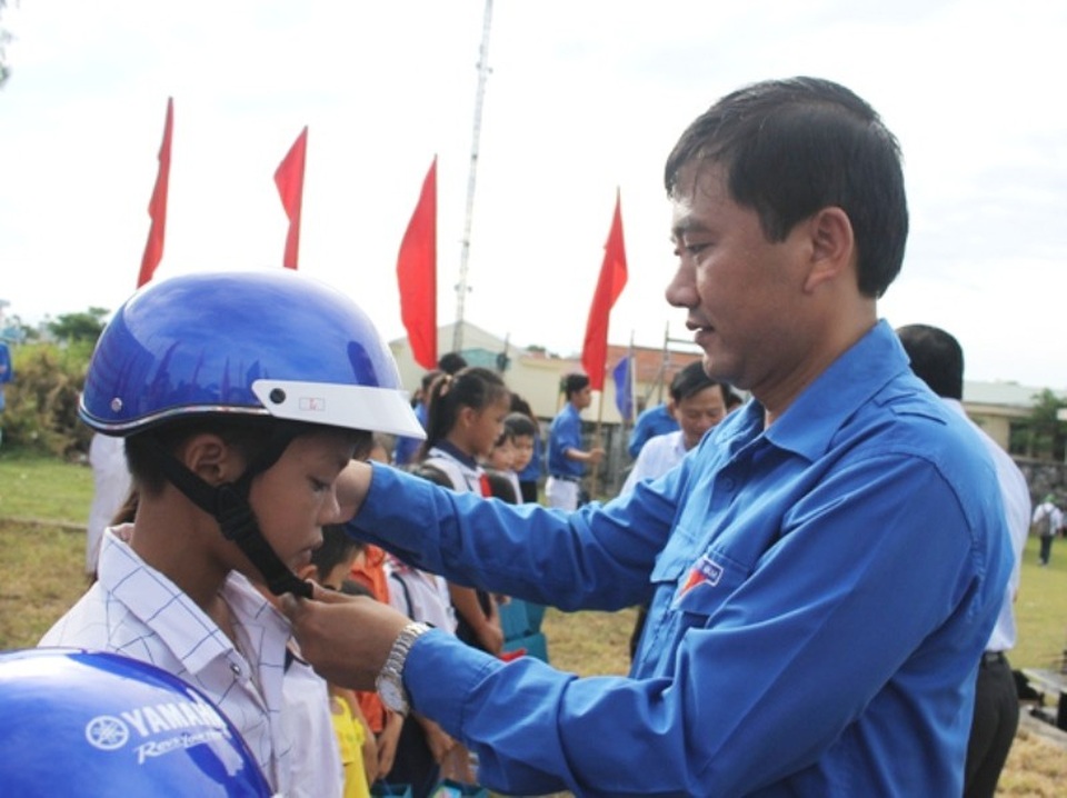 Tuổi trẻ Bình Định phấn đấu xây 10 nhà nhân ái trong Tháng thanh niên - 2 Bí thứ Tỉnh đoàn Bình Định Nguyễn Xuân Vĩnh tặng mũ bảo hiểm cho học sinh.