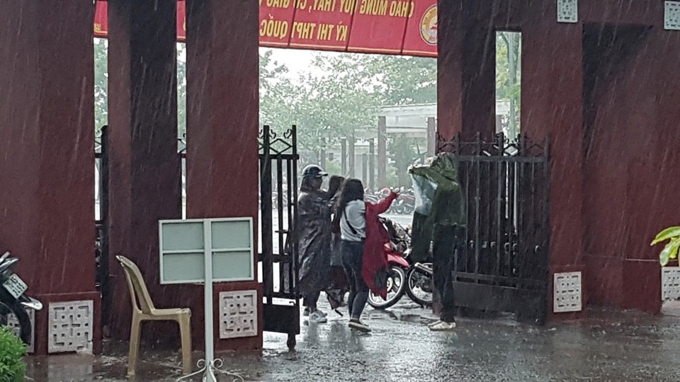 Huế: Phụ huynh đưa con đi làm thủ tục thi trong lốc lớn, mưa dữ dội - 5 Những chiếc áo mưa đưa cho thí sinh để các em trùm vào người chạy vào phòng thi
