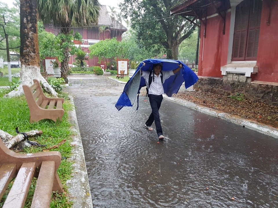 Huế: Phụ huynh đưa con đi làm thủ tục thi trong lốc lớn, mưa dữ dội - 7 Một thí sinh tự mình đi vào phòng thi sau khi có chiếc áo mưa