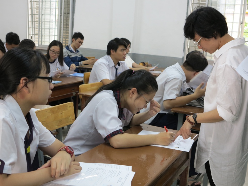 Chùm ảnh: Thí sinh cả nước làm thủ tục dự thi THPT quốc gia 2018 - 20
Cán bộ coi thi hướng dẫn thí sinh chỉnh hồ sơ. (Ảnh: Lê Phương)