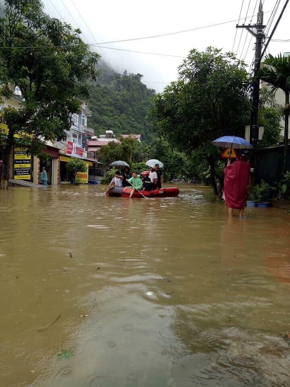 Người dân di chuyển trên phố bằng xuồng caosu.