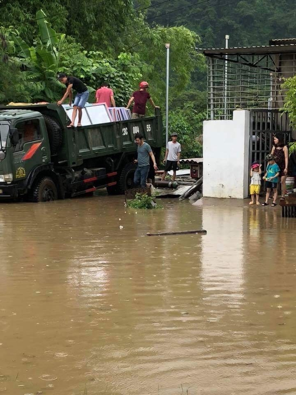 Người dân di chuyển tài sản sau cơn lũ dữ.