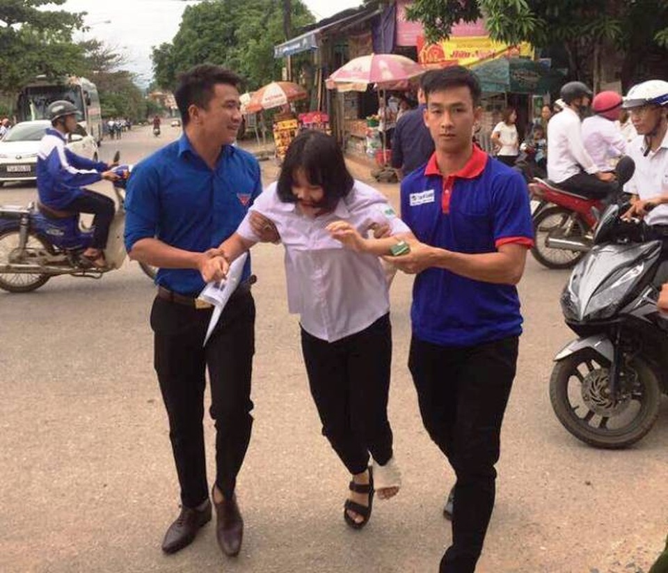 Xúc động cảnh thanh niên tình nguyện dìu thí sinh bị thương vào trường thi - 2 Tình nguyện viên giúp đỡ thí sinh bị đau chân tại điểm thi THPT Vĩnh Linh (Ảnh: Thu Hà)