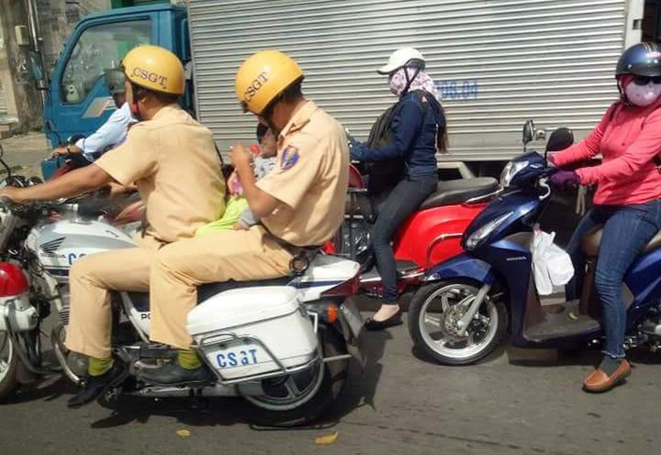 CSGT mở đường, vượt dòng xe ùn tắc đưa cháu bé đi cấp cứu - 2 CSGT điều khiển tìm cách nhanh nhất để đến bệnh viện giữa dòng xe cộ động đúc; trong khi người đồng đội vỗ về, cho bé uống nước. Hình ảnh đã gây xúc động mạnh đối với người dân chứng kiến.