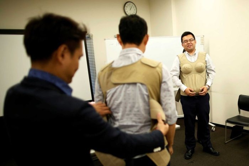 
Các học viên tham gia lớp học làm cha trải nghiệm cảm giác mang bầu của phụ nữ qua một trang phục đặc biệt. (Ảnh: ABC News)
