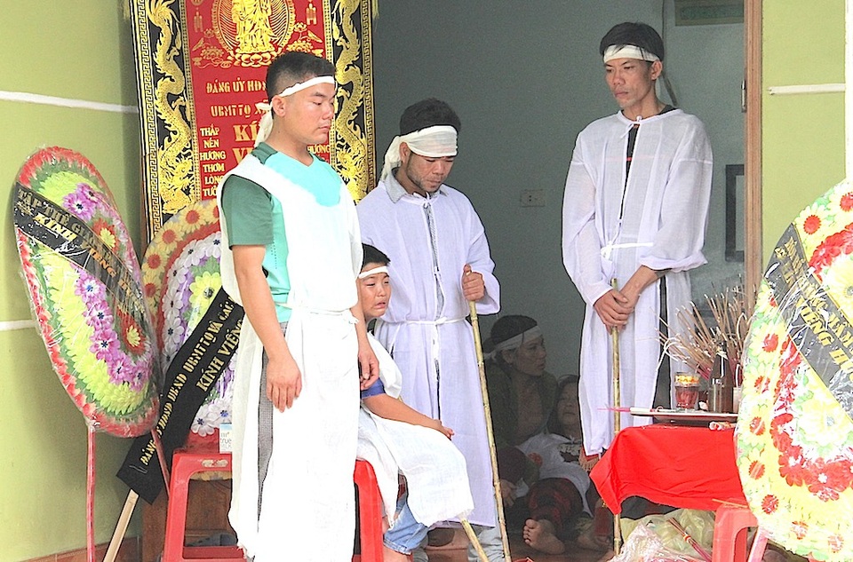 4 đám tang phủ đau thương lên xóm nghèo - 1 Chị Chuyên, các con khóc ngất bên cạnh quan tài chồng.