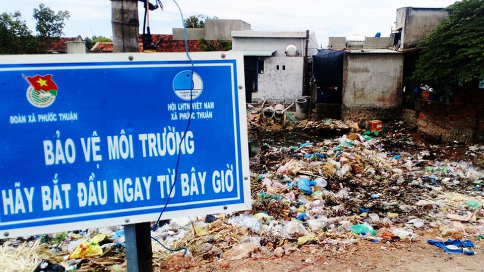 Cực hình suốt 10 năm ngửi mùi hôi thối từ bãi rác - 2 Sau tấm biển bảo vệ môi trường là bãi rác bao vây nhà dân.