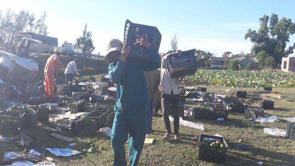 Người dân giúp tài xế gặp nạn thu gom số trái cây bị tràn ra đường