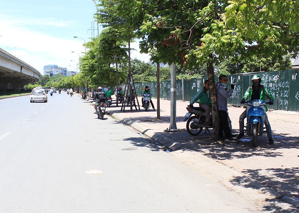Đường phố Hà Nội như "chảo lửa"! - 9
Nhiều tài xế xe ôm dọc tuyến đường Phạm Hùng cố núp mình dưới những tán cây nhỏ bé chờ khách, kiệt sức dưới cái nắng hắt xuống đường chói chang, gắt gỏng.