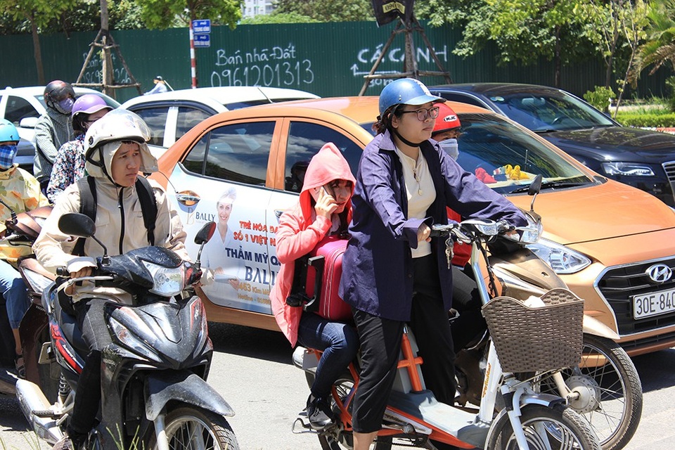 Đường phố Hà Nội như "chảo lửa"! - 5
Chờ đèn đỏ ở những đoạn đường vắng bóng cây xanh là một cực hình đối với người sử dụng xe hai bánh.