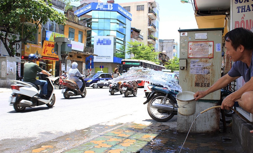 Đường phố Hà Nội như "chảo lửa"! - 7
Trên phố Khâm Thiên, người đàn ông này liên tục đổ những xô nước ra trước cửa để giảm bớt hơi nóng hắt lên từ mặt đường nhựa.