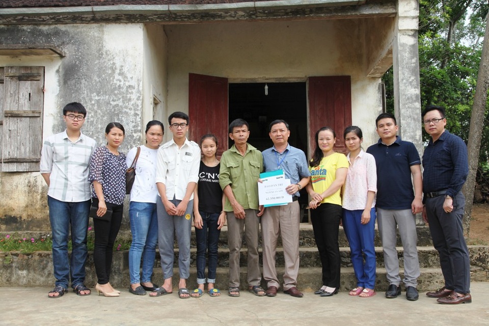 PV Dân trí cùng đại diện nhà trường, cán bộ xã trao quà của bạn đọc Báo điện tử Dân trí tới gia đình ông Sơn.