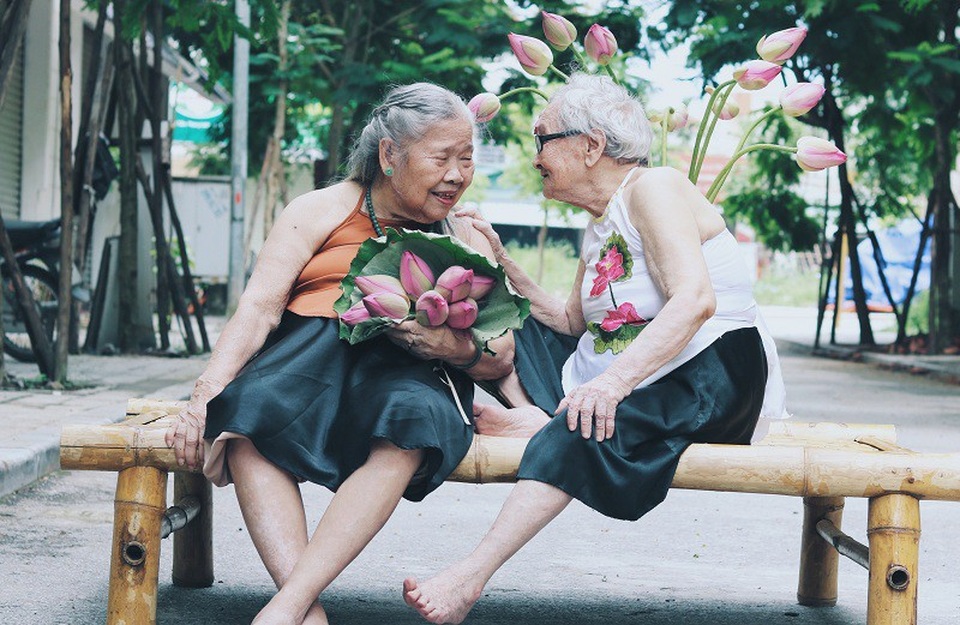 Trong ảnh là cụ bà Nguyễn Thị Kim (87 tuổi) mặc váy đen, yếm cam đất còn bên cạnh là cụ bà Trần Thị Yên (89 tuổi) mặc yếm trắng. Hai cụ đều đang sống trong một trung tâm dưỡng lão tại Hà Nội.