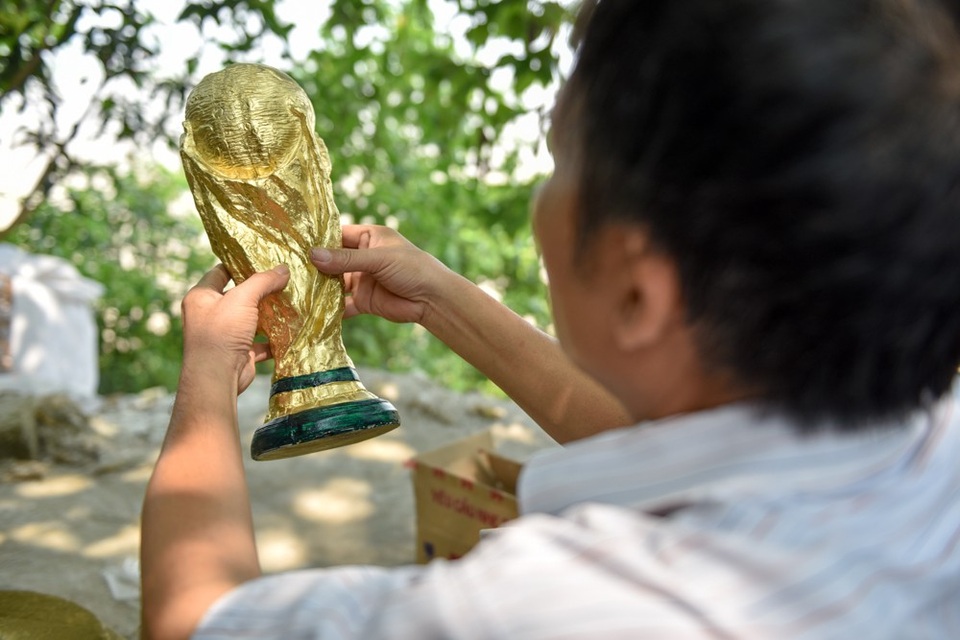 "Đột nhập" xưởng làm cúp vàng World Cup ở làng gốm Bát Tràng - 8
Cúp vàng World Cup thật cao 36,5 cm, được làm từ 5 kg vàng 18 carat (tỷ lệ 75% vàng). Đế cúp có đường kính 13 cm gồm hai lớp đá xanh, phía dưới có dòng chữ FIFA World Cup. Bên trên cúp xoắn ốc tạo hình hai cầu thủ đang đón lấy quả địa cầu và nâng cao như một biểu tượng cho chiến thắng.