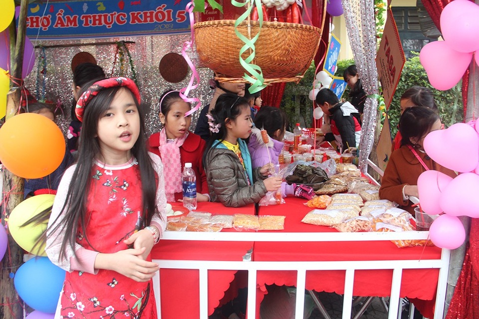 Rộn ràng “Hội chợ tuổi thơ” cho các em học sinh tiểu học - 2
Tham gia hội chợ có 6 gian hàng do các chi đội trường thực hiện. Mỗi gian hàng bày bán các sản phẩm khác nhau như: rau, củ, quả, trứng, bánh chưng, dưa muối, mứt Tết, đồ ăn nhanh…, mang sắc thái riêng biệt, đặc trưng của từng chi đội.