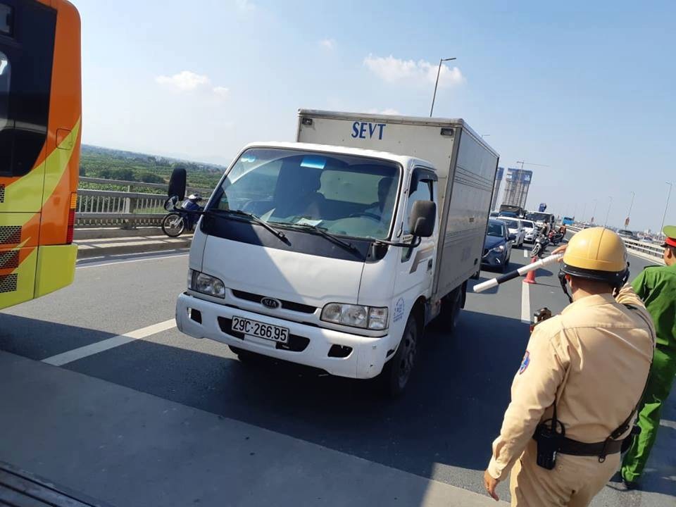 Hà Nội: Xe tải lật ngửa chắn ngang cầu Nhật Tân - 3
Luồng giao thông hướng từ Đông Anh về trung tâm Hà Nội, xe cộ đi lại khó khăn.