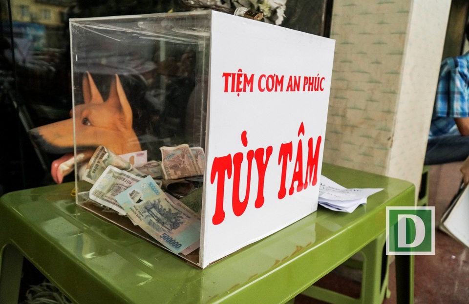 
Một hòm từ thiện được đặt ngoài cửa quán cơm, khách hàng có thể tùy tâm quyên góp tiền.
