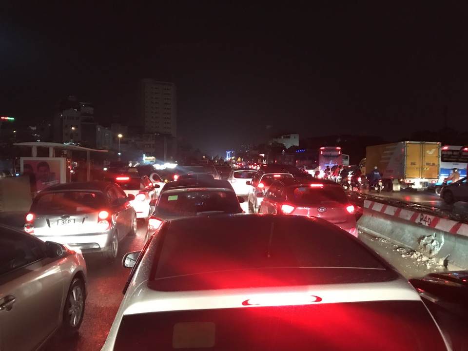 Dòng phương tiện bị ùn ứ kéo dài trên đường Phạm Văn Đồng hướng cầu Thăng Long lúc 19h30 tối nay, do đường bị ngập đoạn giao ngã tư Cổ Nhuế - Trần Cung.