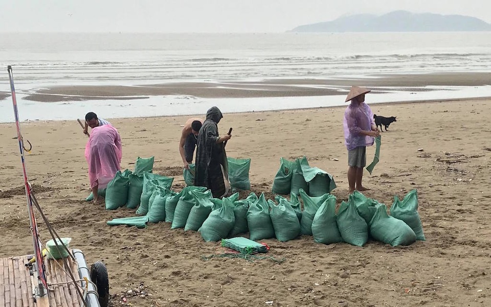 "Chạy đua" với Sơn Tinh: Kéo thuyền lên đường, hạ mái xuống đất - 17 Xúc các bao tải cát để chặn lên mái nhà.