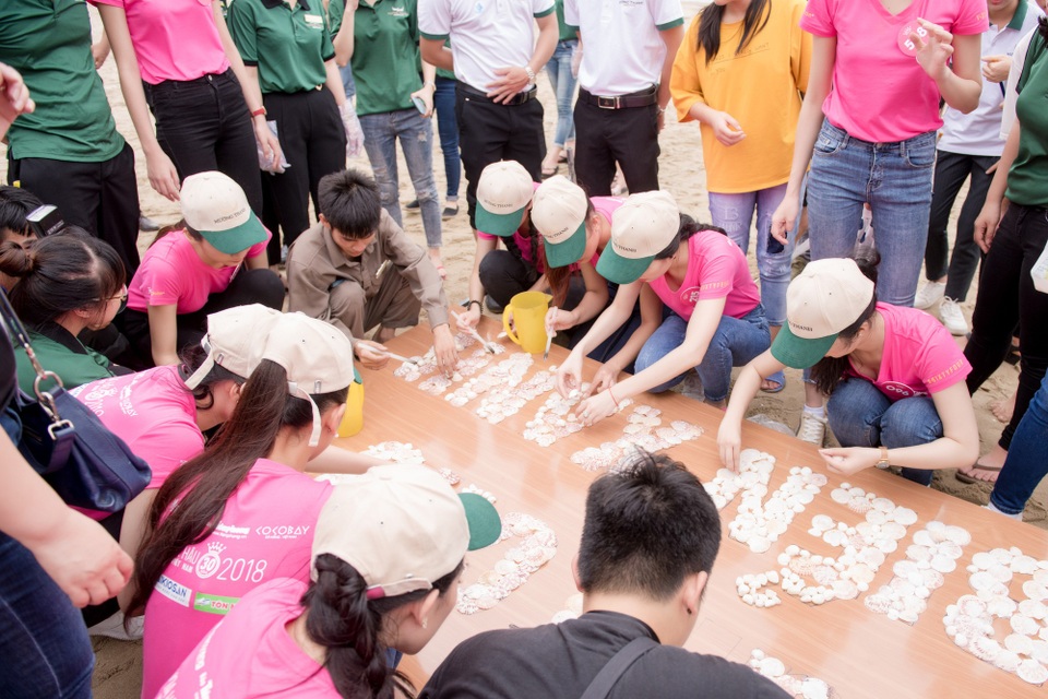 Thí sinh Hoa hậu Việt Nam tham gia làm sạch biển Cửa Lò - 8 Trong khi nhóm 1 tham gia dọn rác dọc bãi biển thì nhóm 2 phụ trách trang trí bảng hiệu kêu gọi với chủ đề “Giữ cho biển xanh” bằng vỏ sò, sỏi