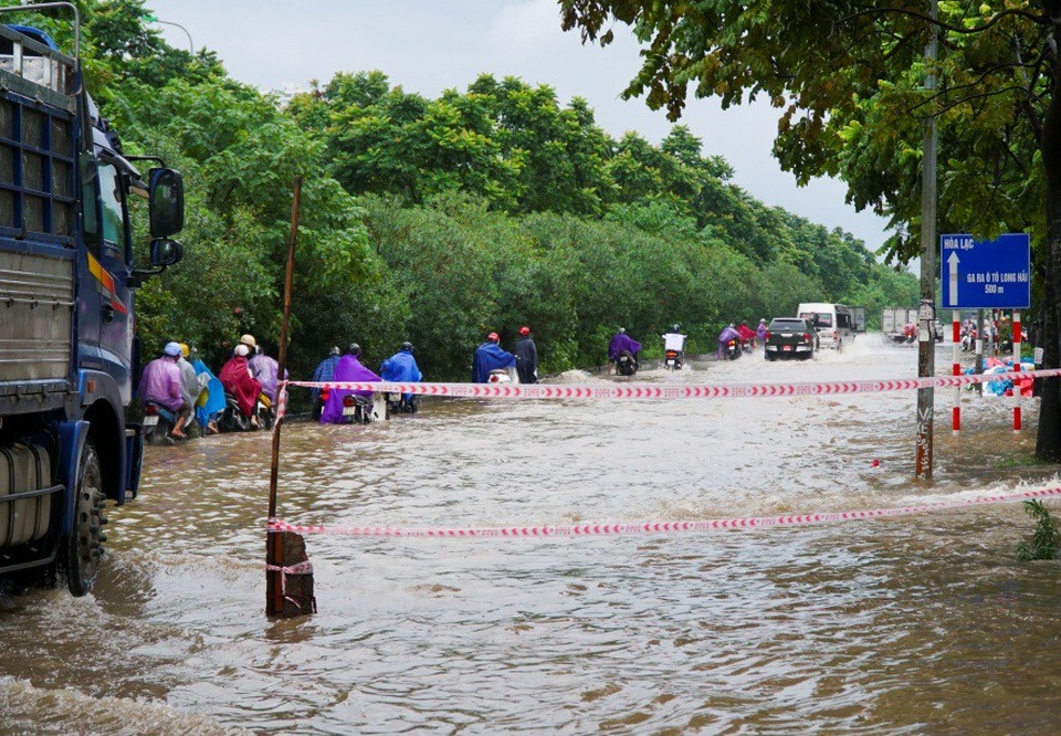 
Đoạn ngập úng trên đường gom Đại lộ Thăng Long bắt đầu từ đoạn rẽ vào đường Lê Trọng Tấn kéo dài khoảng gần 1 km với nhiều đoạn ngập sâu 0,8 - 1m.
