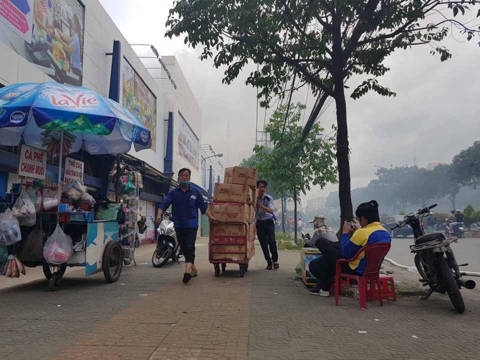 Xưởng gỗ cạnh siêu thị bốc cháy, nhân viên nháo nhào "chạy" hàng hóa - 4 Nhiều hàng hóa được nhân viên di dời ra khỏi siêu thị để đảm bảo an toàn
