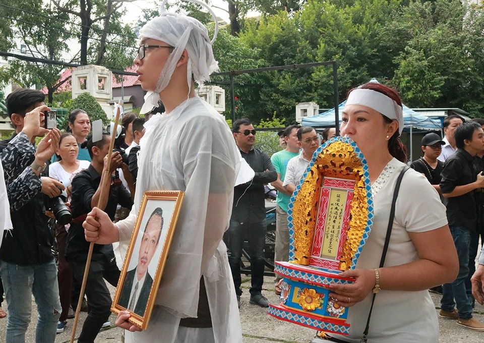 Con trai út cầm di ảnh của cha mình