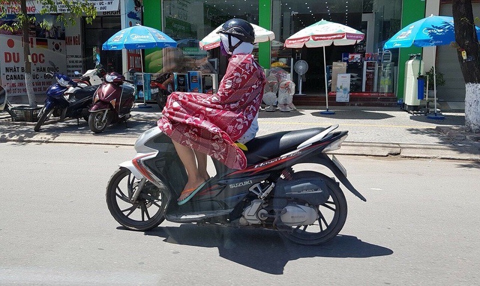 Quảng Bình: Người dân gồng mình chống chịu cái nắng như đổ lửa - 2 Thời tiết nắng nóng, oi bức khiến ai cũng cảm thấy khó chịu, theo ghi nhận của phóng viên, hầu hết người dân ra đường đều bịt kín người để tránh nóng với vật dụng từ khẩu trang, áo chống nắng, kính râm đến áo khoác...