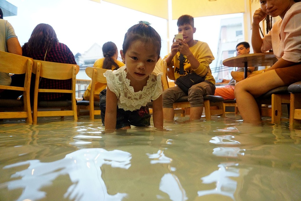 Trẻ em thích thú vui đùa với những chú cá trong hồ nước.