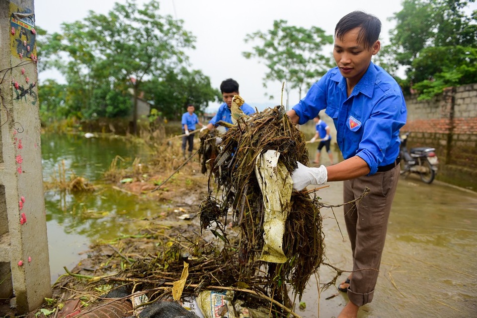 Bột vôi diệt khuẩn phủ trắng vùng ngập Hà Nội - 10
Đội thanh niên tình nguyện cũng giúp người dân dọn dẹp rác ở trong khu dân cư.
