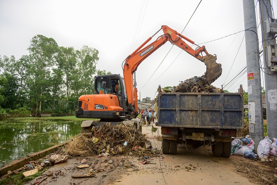 Bột vôi diệt khuẩn phủ trắng vùng ngập Hà Nội - 13
Sau ngập, nhiều rác ứ đọng khắp nơi, các phương tiện cơ giới được huy động để dọn dẹp.