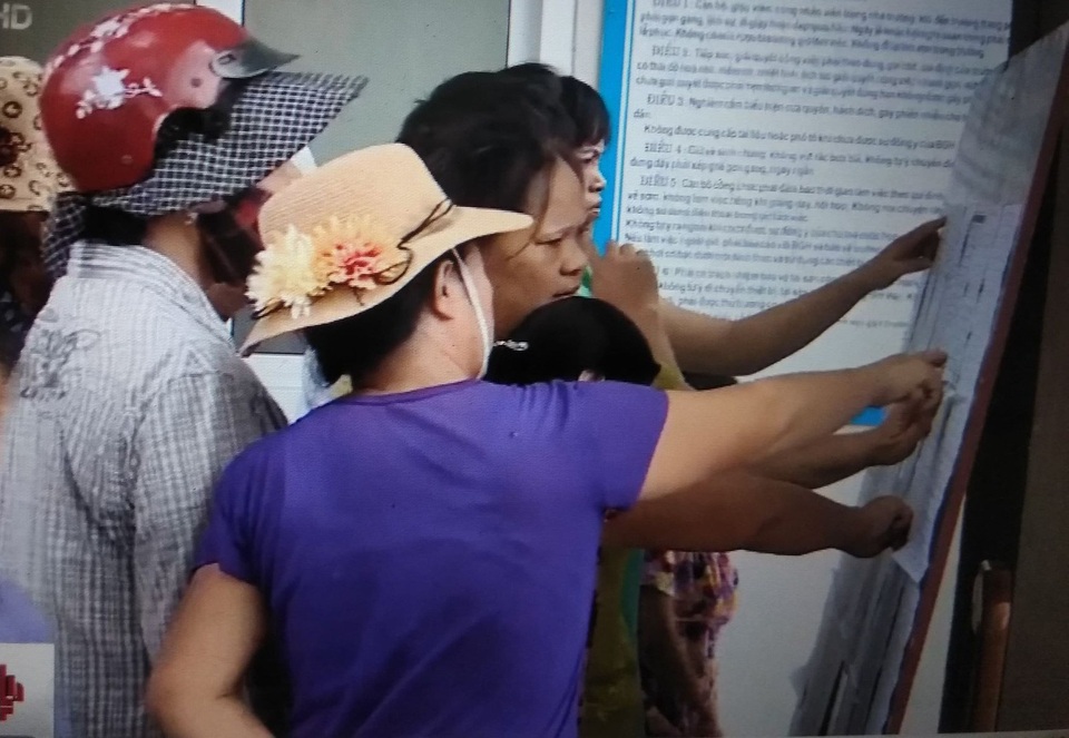 Hà Nội: Hàng trăm phụ huynh “bao vây” cổng trường vì phân tuyến - 2 Phụ huynh đang trực tiếp xem thông tin tuyển sinh được dán ở cổng Trường tiểu học Cao Báo Quát.