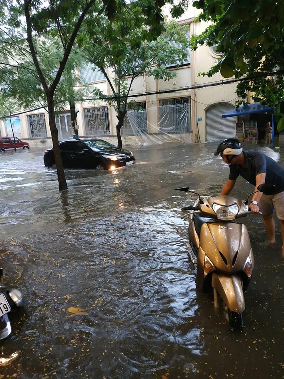 
Xe máy dù được dắt bộ cũng chao đảo mỗi khi có xe ô tô chạy qua tại đường Minh Khai
