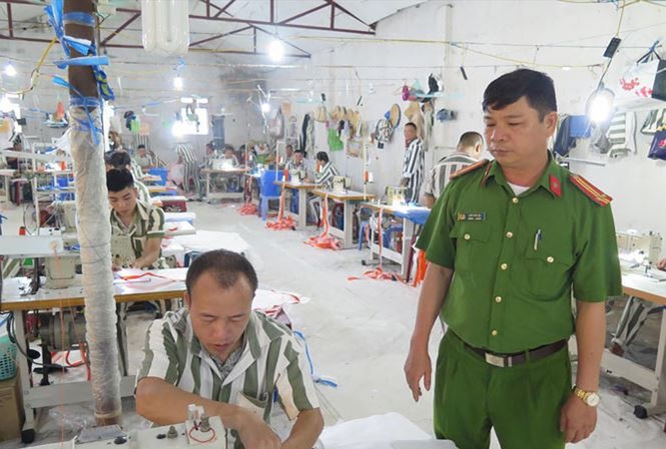 
Trung tá Lâm Văn Lợi cùng các phạm nhân làm việc tại xưởng may.
