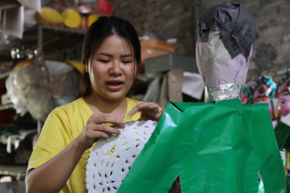 Thâm nhập thủ phủ sản xuất “osin, chân dài” cho người cõi âm - 10 Chị Huyền (SN 1994) tất bật hoàn thiện các sản phẩm vàng mã phục vụ dịp cúng “cô hồn” tháng 7 âm lịch. Ngoài các thành viên trong gia đình, nhà chị Huyền phải thuê thêm khoảng 10 nhân công để sản xuất vàng mã quanh năm.