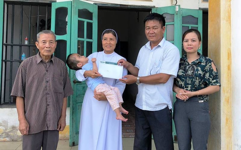 Ông Phạm Văn Vịnh, Phó chủ tịch UBND xã Trung Đông trao quà đến bé Mai Chi