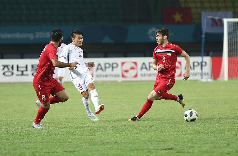 
Quang Hải (giữa) trong vòng vây của các cầu thủ Olympic Syria

