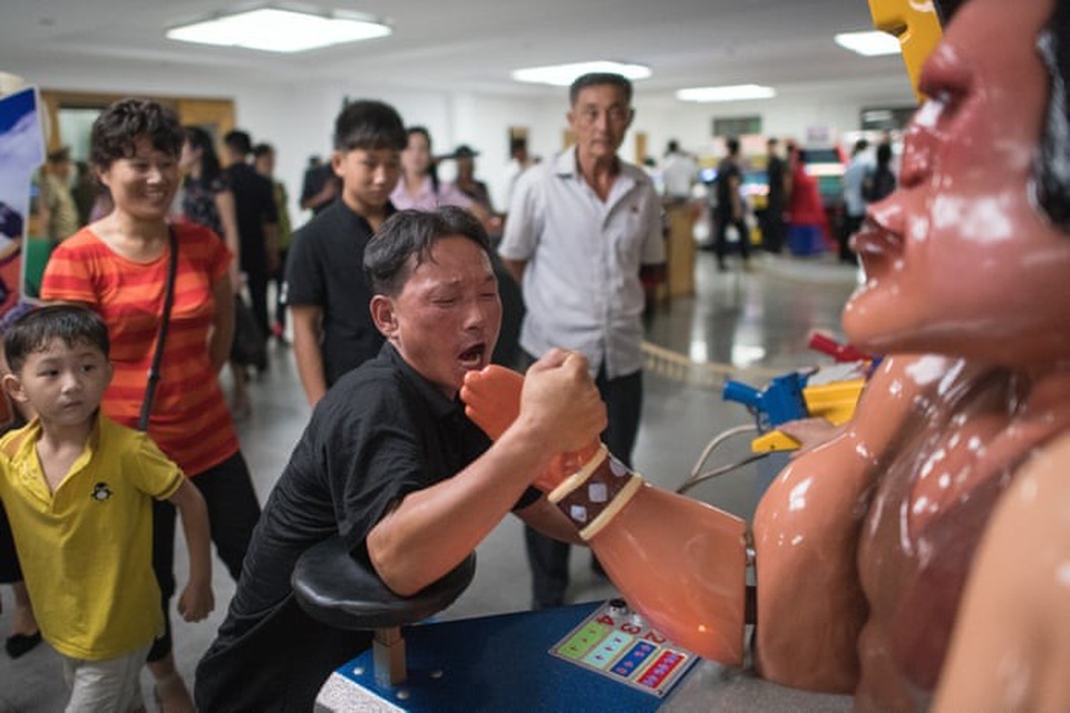 Khoảnh khắc thư giãn bình dị của người Triều Tiên - 6 Một người đàn ông chơi trò vật tay tại khu giải trí bên trong công viên tuổi trẻ Kaeson.